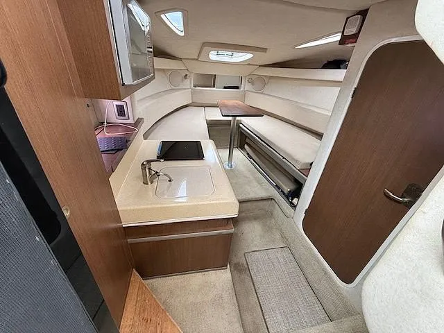 Slide: The Image of Interior of 2013 Sea Ray 260 Sundancer boat, featuring kitchenette and seating area. - 13
