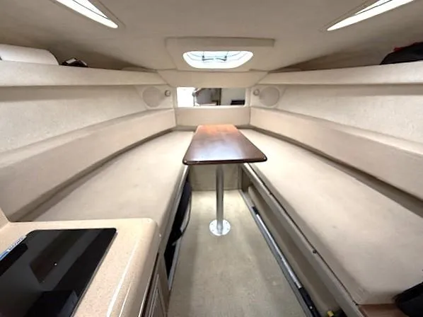 Slide: The Image of Interior of 2013 Sea Ray 260 Sundancer boat with beige seating and wooden table. - 14