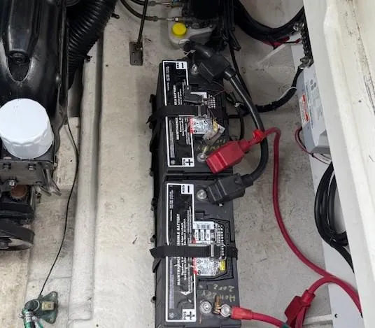 Slide: The Image of Battery compartment of a 2013 Sea Ray 260 Sundancer boat, showing two connected batteries. - 21