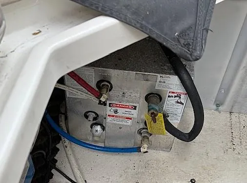 Slide: The Image of 2013 Sea Ray 260 Sundancer boat component with warning labels and connected hoses. - 24