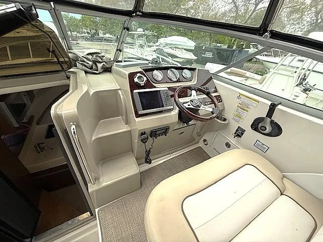 Slide: The Image of 2013 Sea Ray 260 Sundancer helm with steering wheel, gauges, and navigation system. - 6