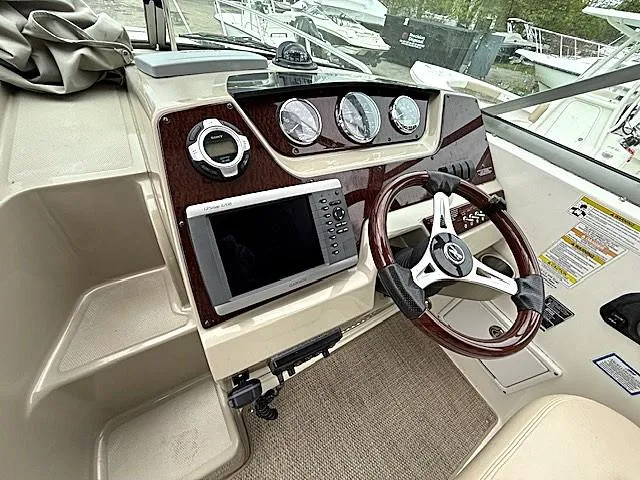 Slide: The Image of 2013 Sea Ray 260 Sundancer helm with steering wheel, gauges, and navigation system. - 7