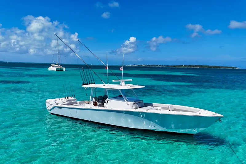Slide: The Image of 2021 Jupiter 43 boat anchored in clear turquoise waters under a bright blue sky. - 1