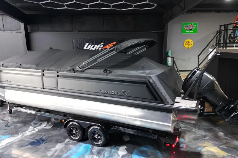 Slide: The Image of 2026 Viaggio Lago Z-U 24 pontoon boat with cover, displayed indoors on a trailer. - 21