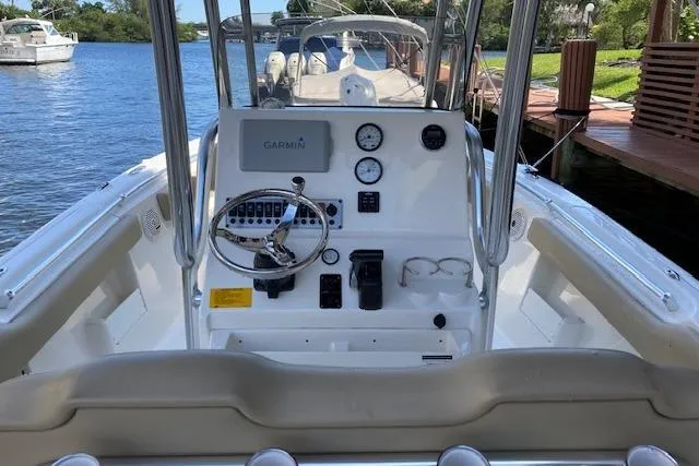 Slide: The Image of 2017 Key West 239 FS boat cockpit with Garmin navigation, steering wheel, and gauges on a calm waterway. - 5