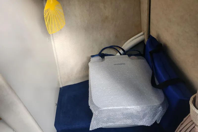 Slide: The Image of Interior of a 2003 Sea Ray 225 Weekender with bubble-wrapped item and yellow fly swatter. - 10