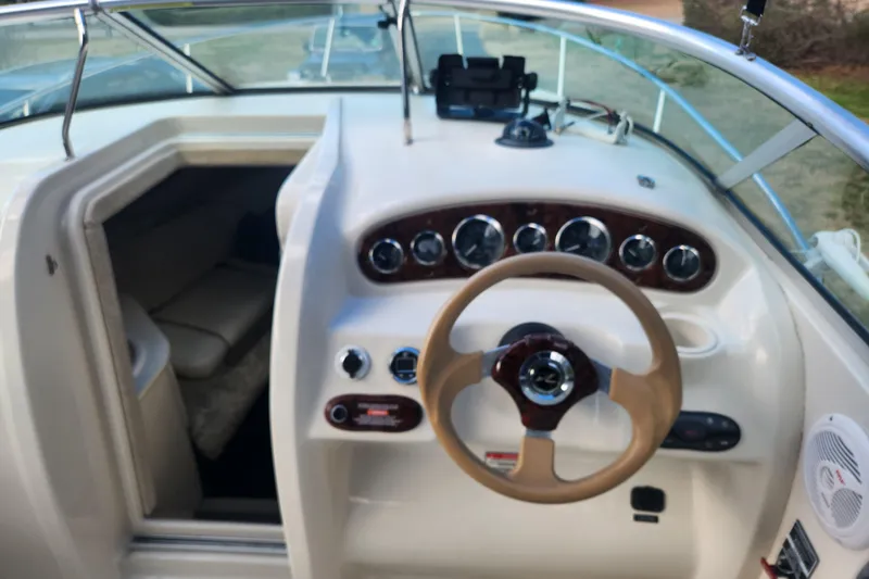 Slide: The Image of 2003 Sea Ray 225 Weekender boat interior with steering wheel and cabin view. - 12