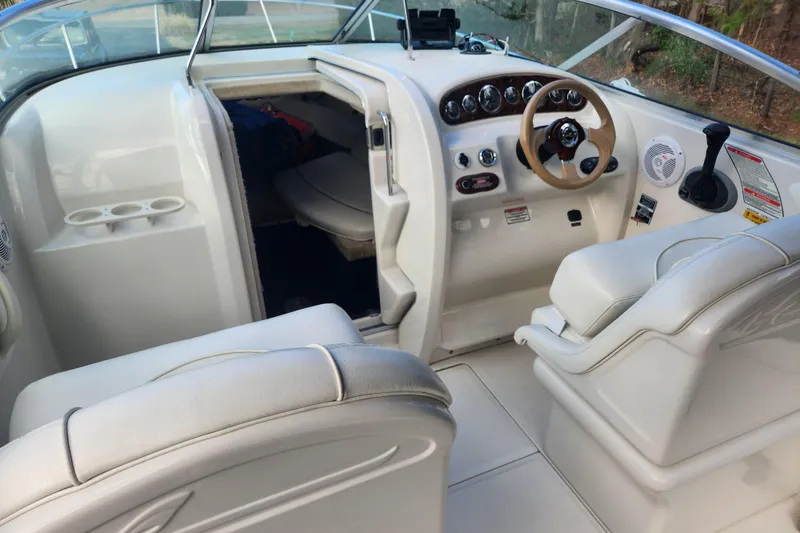 Slide: The Image of Interior of a 2003 Sea Ray 225 Weekender boat, featuring helm and seating area. - 13