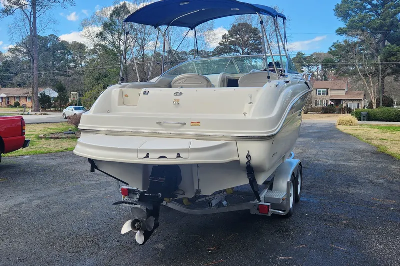 Slide: The Image of 2003 Sea Ray 225 Weekender boat on trailer, parked in residential driveway. - 15