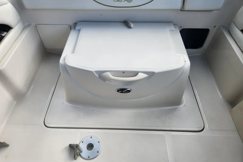 Slide: The Image of 2003 Sea Ray 225 Weekender boat interior with storage compartment and seating area. - 16