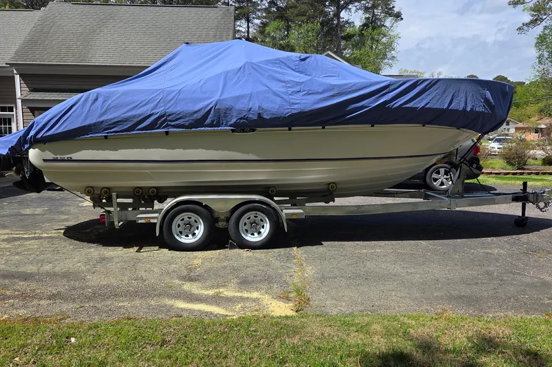 Slide: The Image of 2003 Sea Ray 225 Weekender boat covered with blue tarp on trailer in driveway. - 22