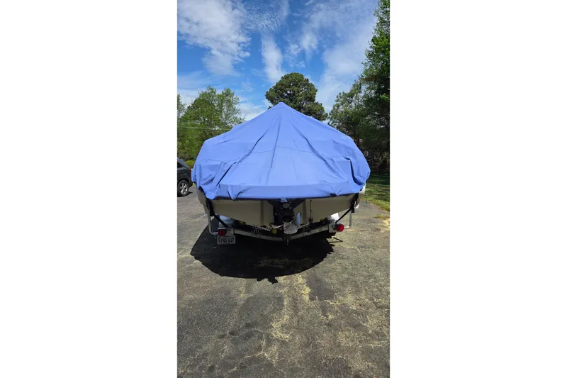 Slide: The Image of 2003 Sea Ray 225 Weekender boat covered with a blue tarp, parked outdoors. - 24