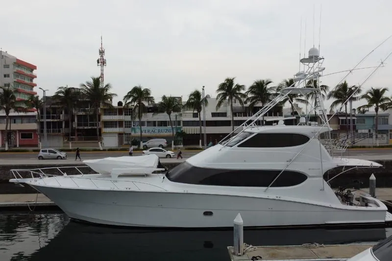 The Image of 2007 Hatteras yacht docked at marina, surrounded by palm trees and urban buildings. - 1