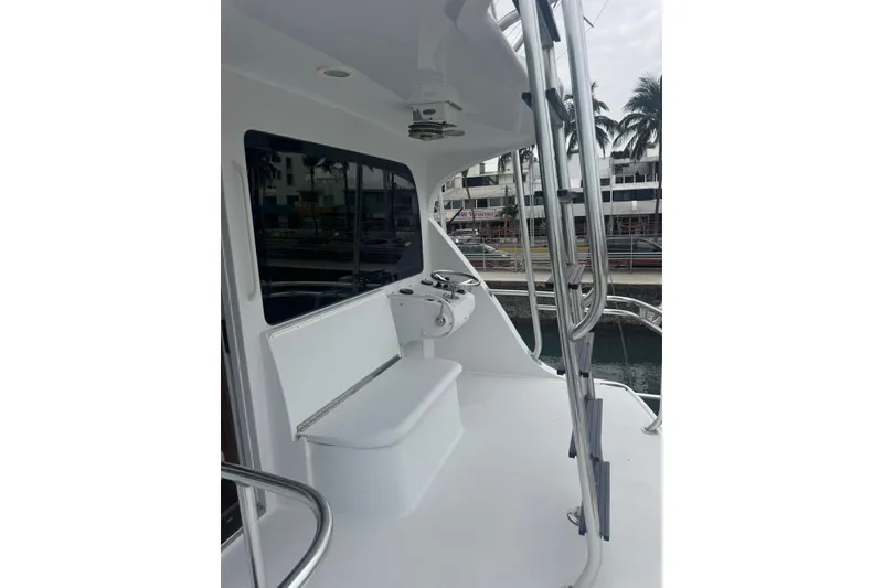 Slide: The Image of 2007 Hatteras yacht deck with seating and helm, docked near palm trees. - 10