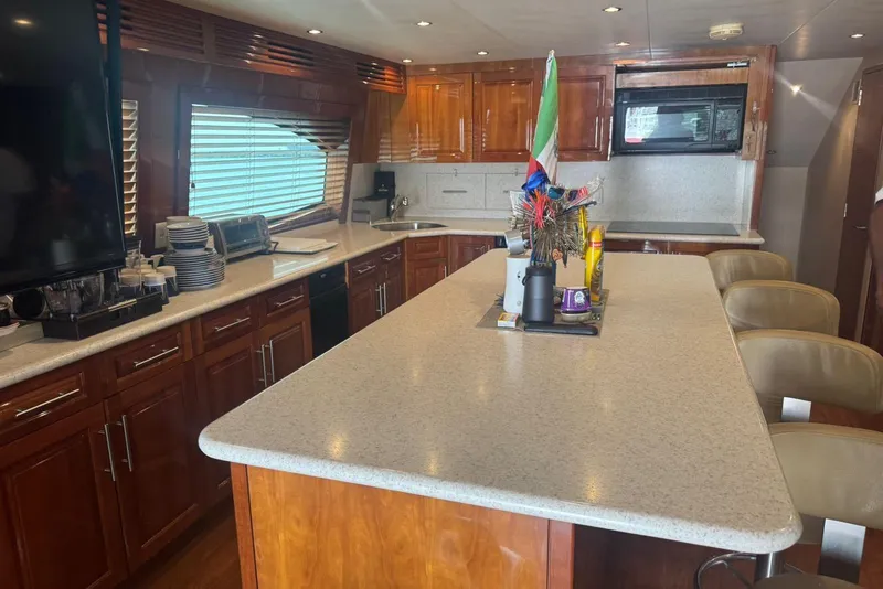 Slide: The Image of Luxurious 2007 Hatteras yacht kitchen with modern appliances and elegant wood cabinetry. - 17