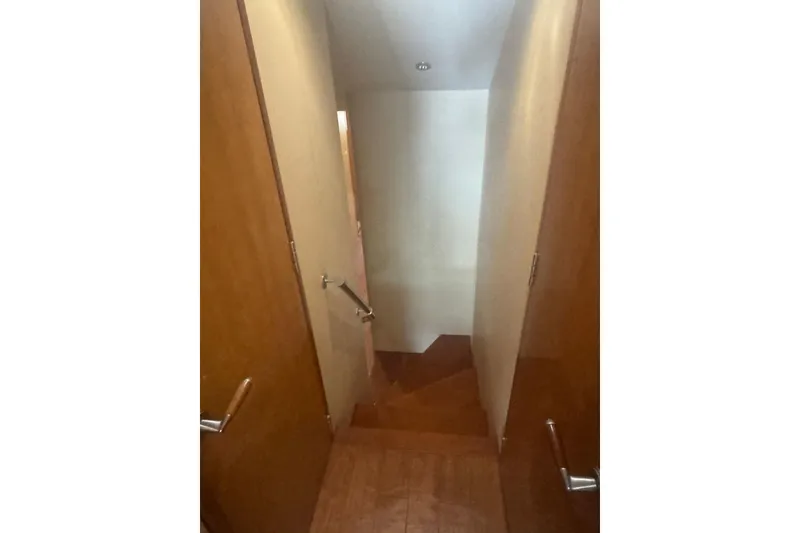 Slide: The Image of Narrow wooden hallway with stairs inside a 2007 Hatteras boat. - 23