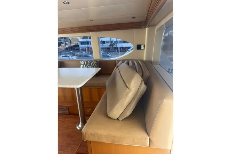 Slide: The Image of Interior of a 2007 Hatteras yacht featuring a beige seating area and dining table. - 27