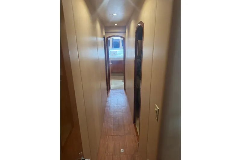 Slide: The Image of Hallway interior of a 2007 Hatteras yacht with wooden flooring and soft lighting. - 28