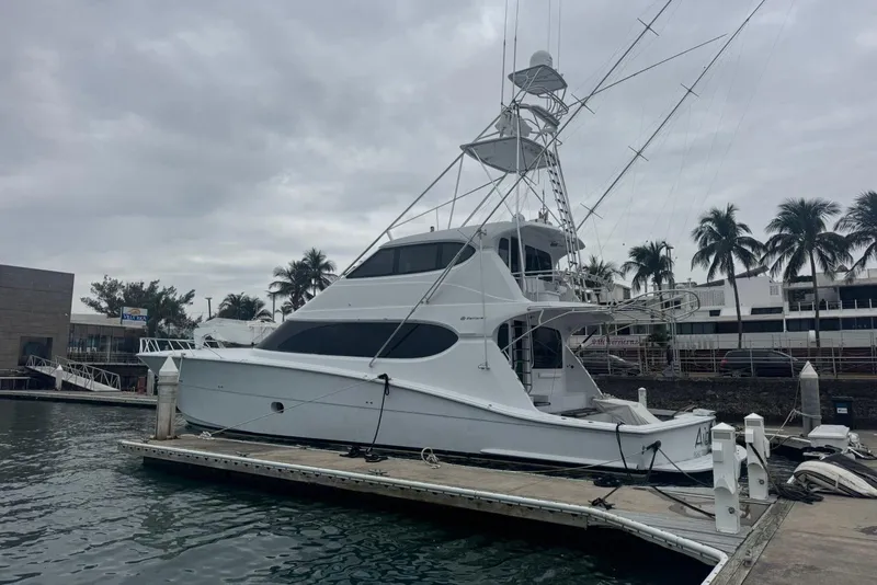 Slide: The Image of 2007 Hatteras yacht docked at marina with palm trees and cloudy sky. - 5
