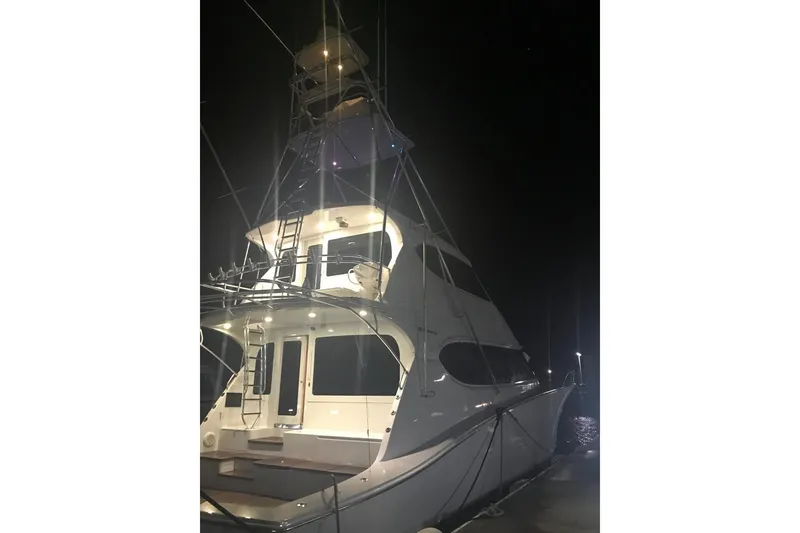 Slide: The Image of Illuminated 2007 Hatteras yacht docked at night, showcasing sleek design and multiple decks. - 6
