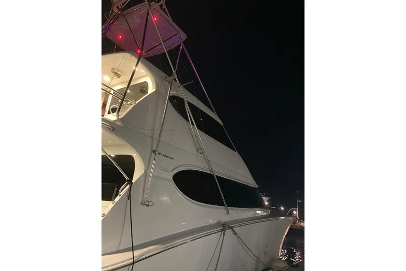 Slide: The Image of 2007 Hatteras yacht illuminated at night, showcasing sleek design and modern architecture. - 7