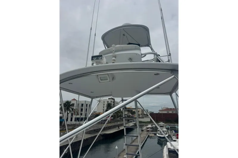 Slide: The Image of 2007 Hatteras boat with elevated helm, docked in marina under cloudy sky. - 9