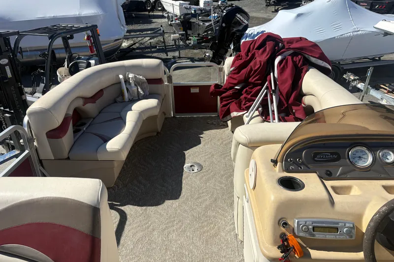 Slide: The Image of 2011 Sylvan 820 Mirage Cruise boat interior with beige seating and dashboard. - 13