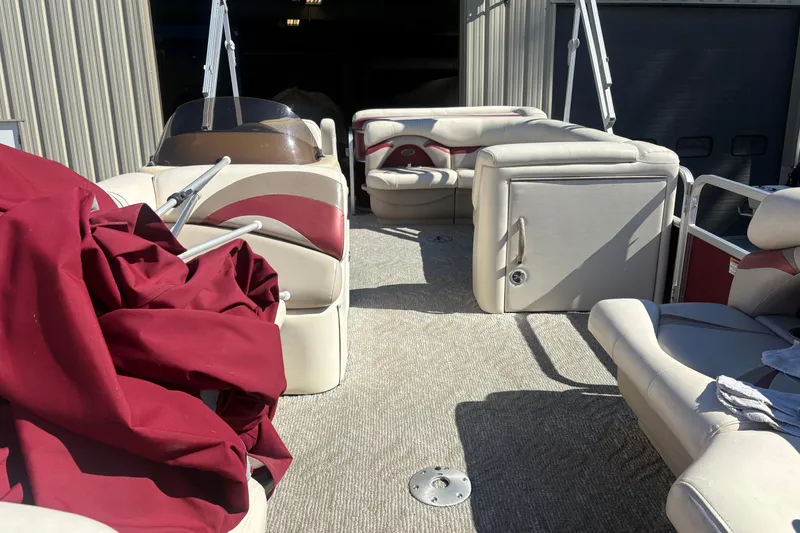 Slide: The Image of 2011 Sylvan 820 Mirage Cruise boat interior with red and beige seating and cover. - 5