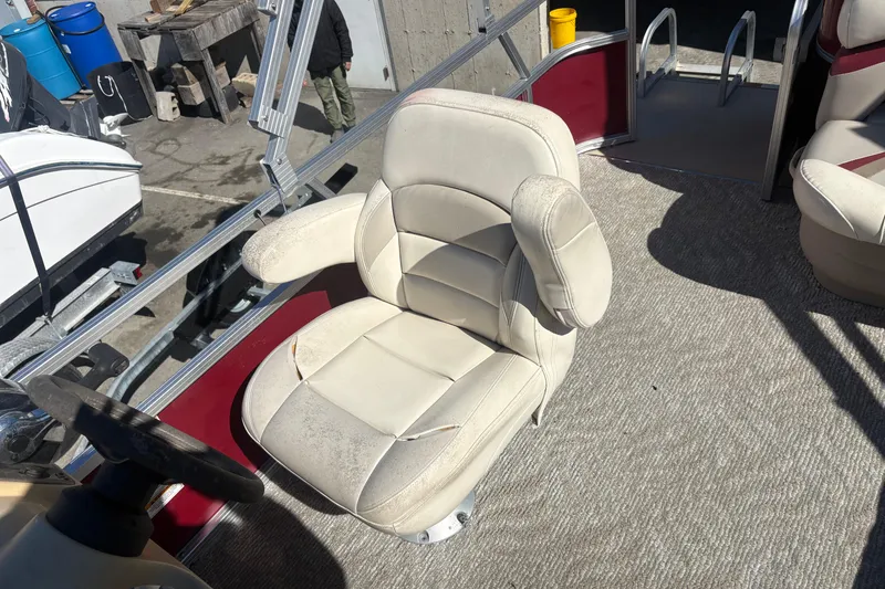 Slide: The Image of 2011 Sylvan 820 Mirage Cruise boat interior with beige captain's chair and steering wheel. - 8