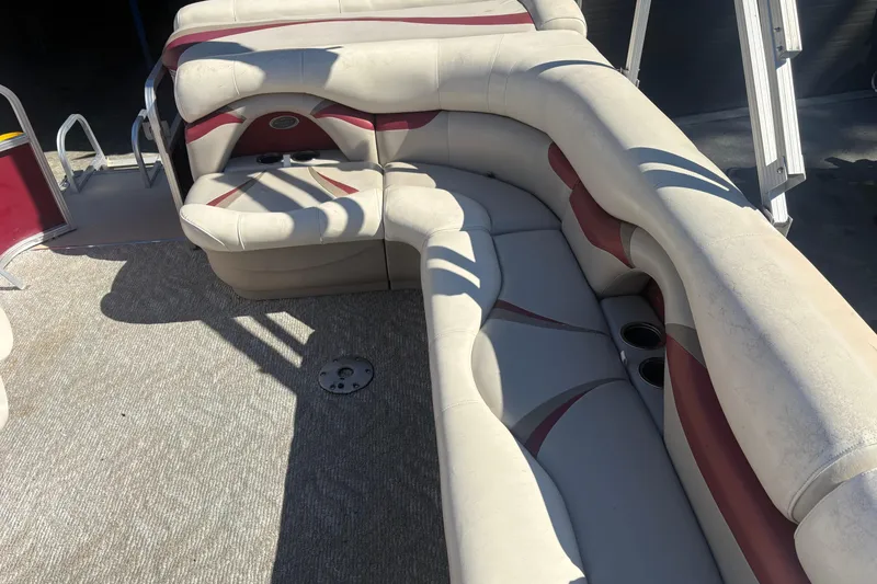 Slide: The Image of 2011 Sylvan 820 Mirage Cruise boat interior with beige and red cushioned seating. - 9