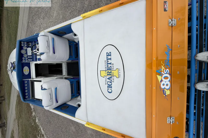 Slide: The Image of 2000 Cigarette 30' Mystique boat interior with branded seating and vibrant orange accents. - 13