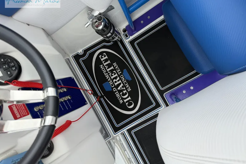 Slide: The Image of Interior of 2000 Cigarette 30' Mystique boat with steering wheel and branded floor mat. - 20