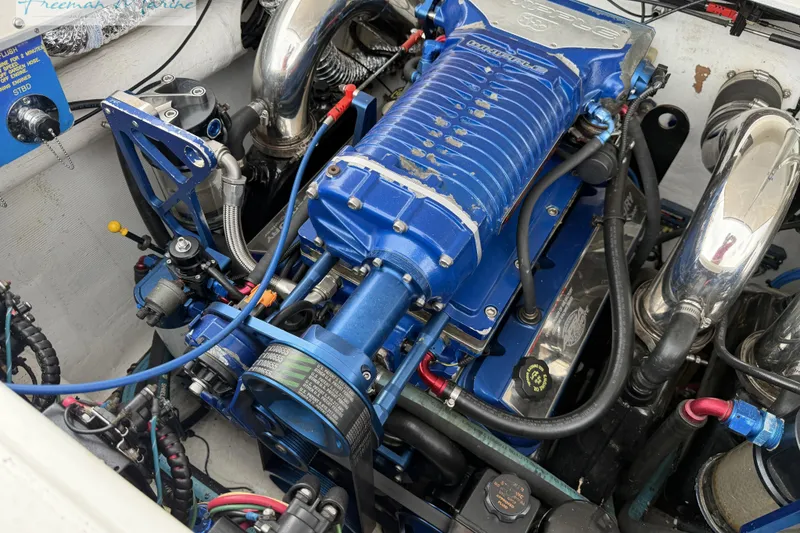 Slide: The Image of Engine of a 2000 Cigarette 30' Mystique boat, featuring blue components and chrome details. - 28