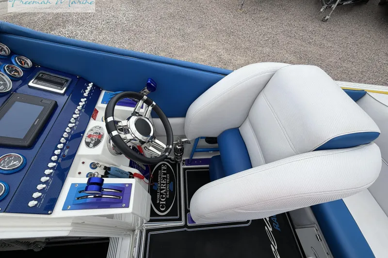 Slide: The Image of Interior of a 2000 Cigarette 30' Mystique boat with steering wheel and control panel. - 34