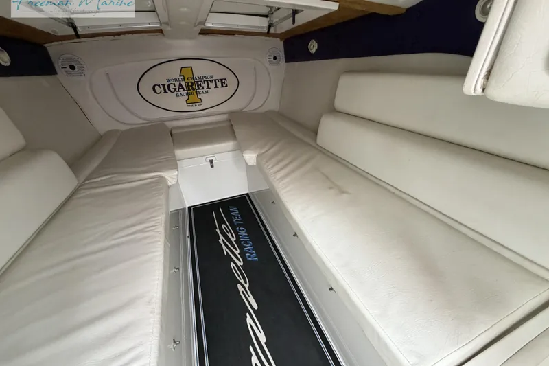 Slide: The Image of Interior of 2000 Cigarette 30' Mystique boat with white seating and branded flooring. - 39