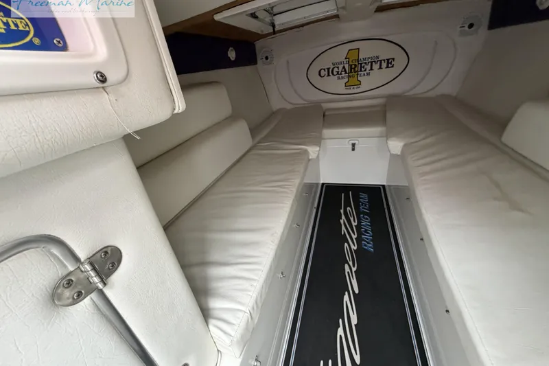 Slide: The Image of Interior of 2000 Cigarette 30' Mystique boat with white seating and branded flooring. - 40