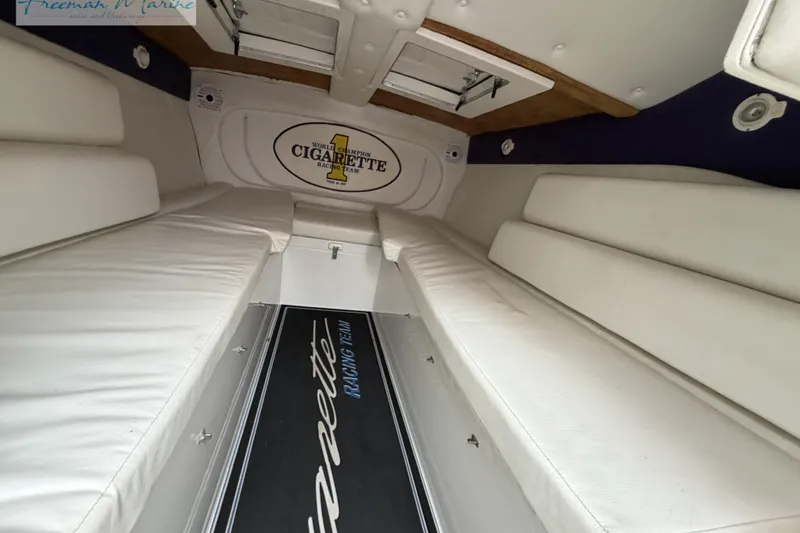 Slide: The Image of Interior of 2000 Cigarette 30' Mystique boat with white seating and branded flooring. - 41