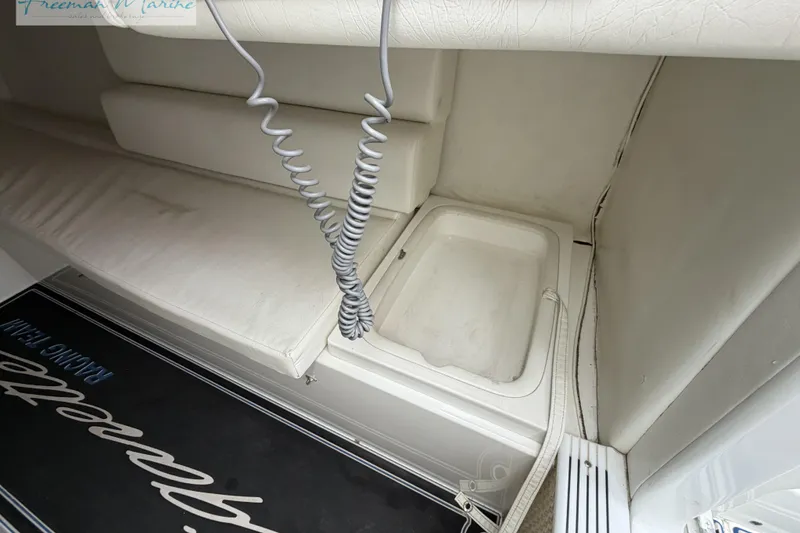 Slide: The Image of Interior of a 2000 Cigarette 30' Mystique boat, featuring white seating and storage. - 43