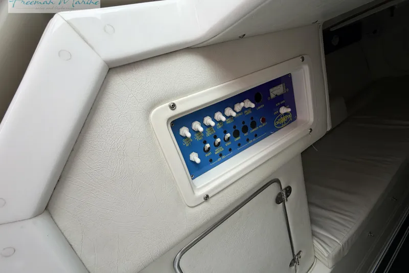 Slide: The Image of Control panel inside 2000 Cigarette 30' Mystique boat, featuring switches and cushioned seating. - 45