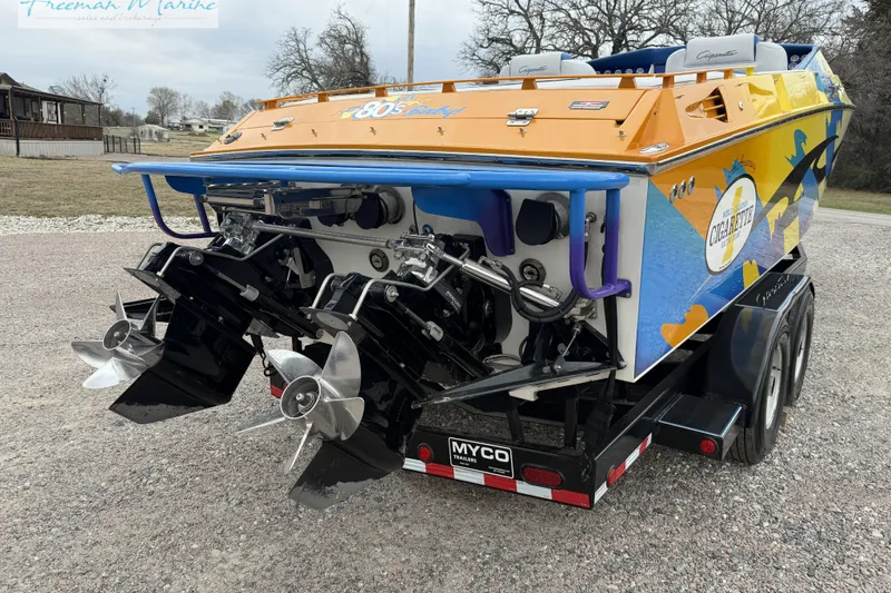 Slide: The Image of 2000 Cigarette 30' Mystique boat on trailer, vibrant design, dual propellers visible. - 5
