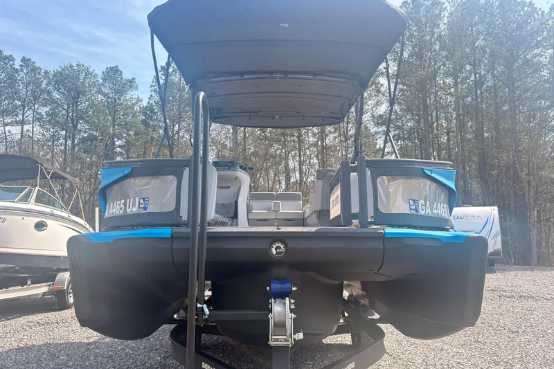 Slide: The Image of 2022 Sea Doo Switch pontoon boat on trailer, parked outdoors with trees in background. - 10