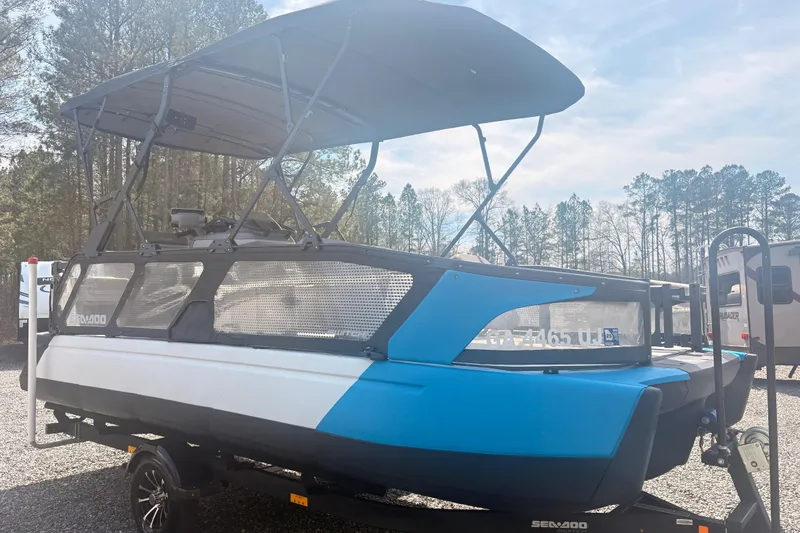 Slide: The Image of 2022 Sea Doo Switch pontoon boat with canopy, parked on a trailer. - 4