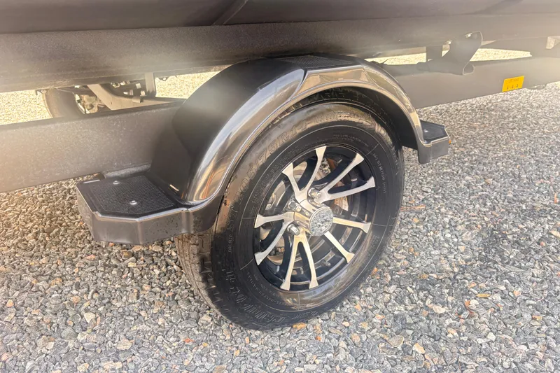 Slide: The Image of 2022 Sea Doo Switch trailer wheel on gravel surface, showcasing sleek design and durability. - 5