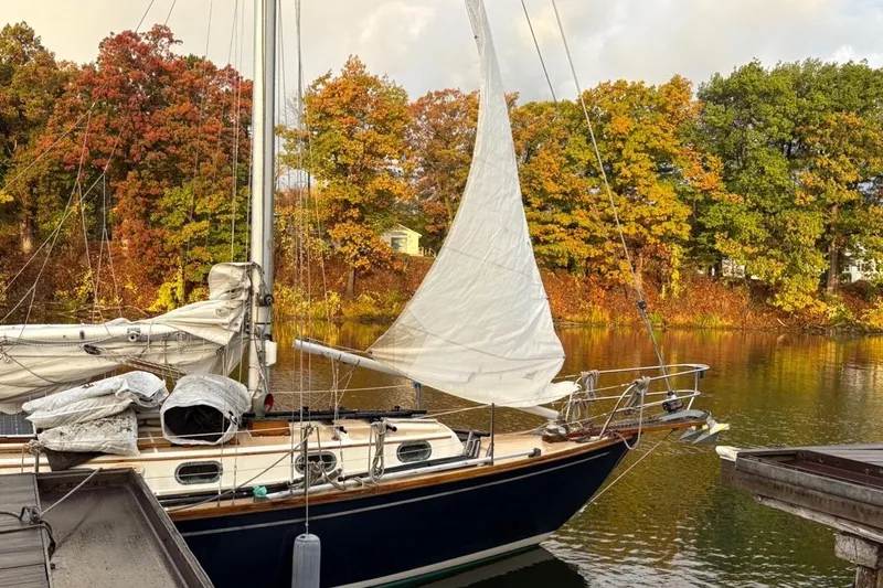 Slide: The Image of 1987 Cape Dory 36 sailboat docked by autumn trees on a calm lake. - 12