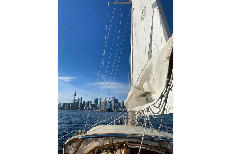 Slide: The Image of Sailing Cape Dory 36, 1987 model, with city skyline and blue sky in the background. - 14