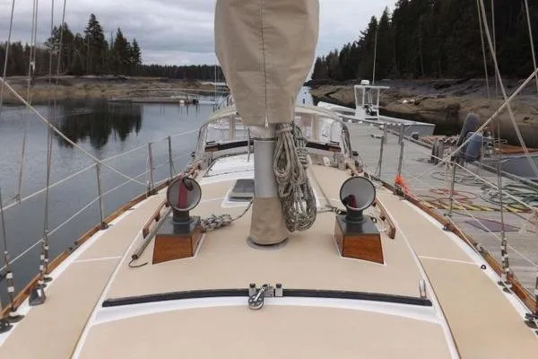 Slide: The Image of 1987 Cape Dory 36 sailboat deck with mast and rigging, docked in a serene marina. - 16