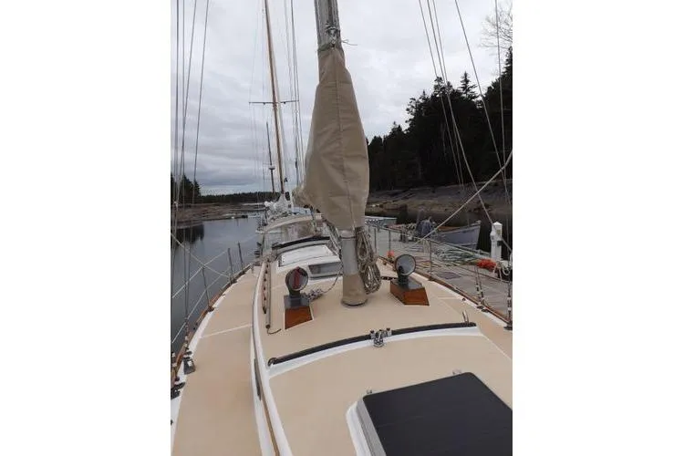 Slide: The Image of 1987 Cape Dory 36 sailboat docked, showcasing deck and mast in a serene marina setting. - 17