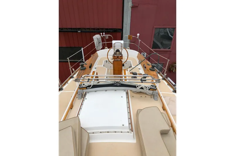 Slide: The Image of 1987 Cape Dory 36 sailboat deck with wooden accents and steering wheel. - 18
