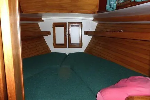 Slide: The Image of 1987 Cape Dory 36 cabin interior with wooden paneling and green cushions. - 22