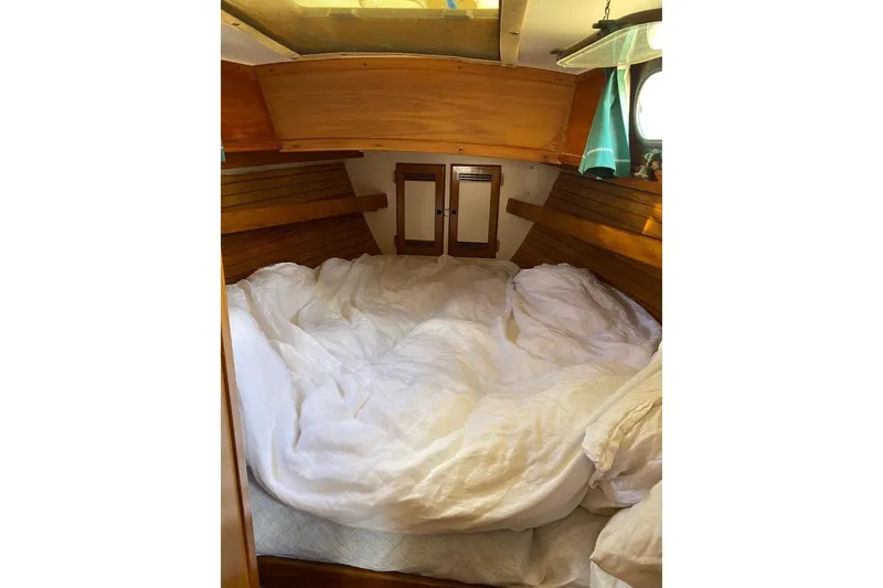 Slide: The Image of Cozy cabin interior of 1987 Cape Dory 36 sailboat with wooden accents and bedding. - 24